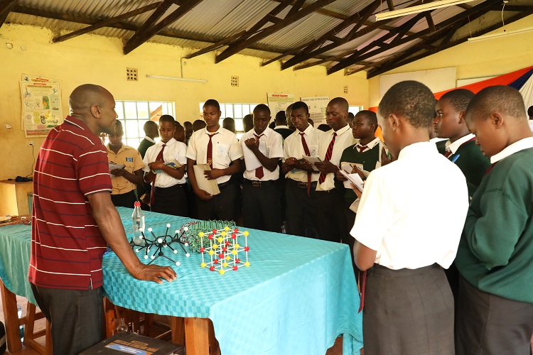 Dr. Karanja Mutito, Coordinator Research at CEMASTEA explaining to learners at Shitoli Secondary School a concept in Bonds using the models during the STEM Outreach.